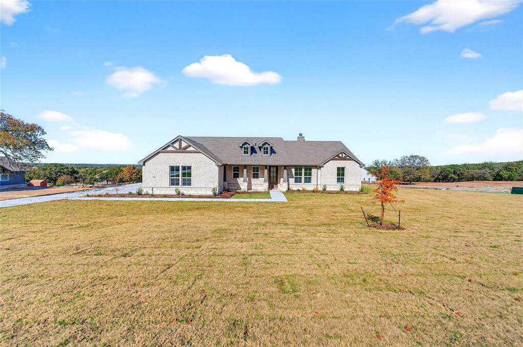 400 Hayden Faith Court Springtown, TX 76082 - Photo 2 of 35 View of front facade with covered porch, a front lawn, brick siding, and a chimney