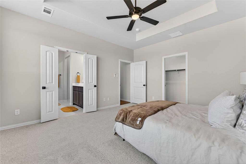400 Hayden Faith Court Springtown, TX 76082 - Photo 22 of 35 a spacious bedroom with a bed and a chandelier