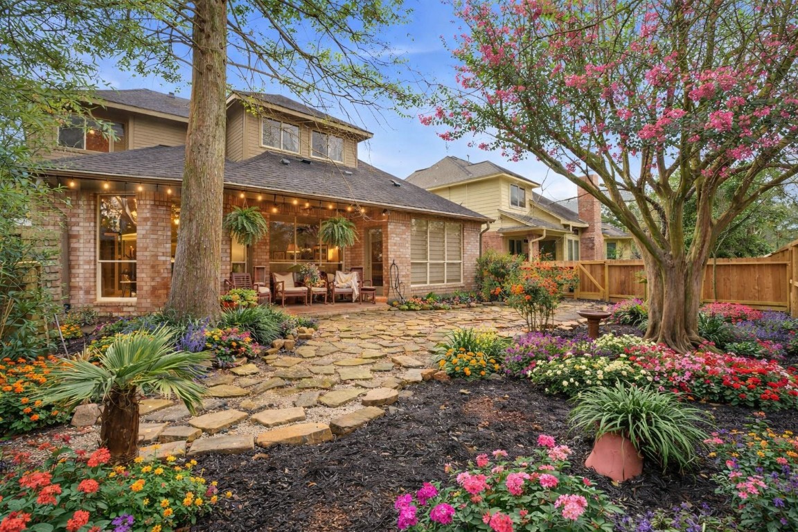 16322 Cranwood Drive Spring, TX 77379 - Photo 18 of 42 Experience effortless outdoor living in this charming yard, featuring a picturesque flagstone pathway framed by lush, low-maintenance landscaping.
