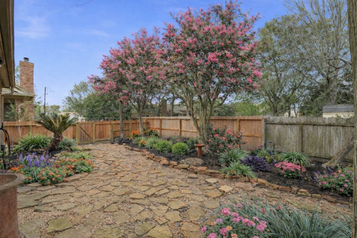16322 Cranwood Drive Spring, TX 77379 - Photo 19 of 42 Discover a serene oasis with mature crepe myrtle trees and a variety of low-maintenance plants, creating a vibrant and inviting garden retreat.