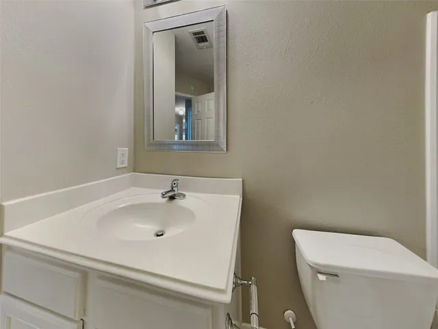a view of a refrigerator in kitchen and an empty room
