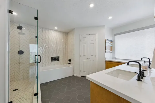 a bathroom with double vanity sink a two mirror a window and vanity