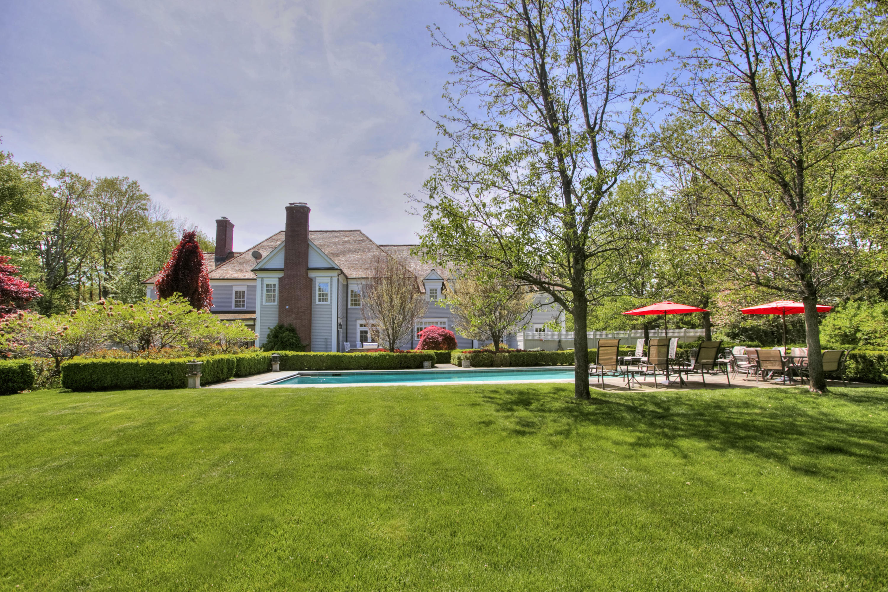 1325 Smith Ridge Road New Canaan, CT 06840 - Photo 20 of 28 a front view of a building with a garden and trees