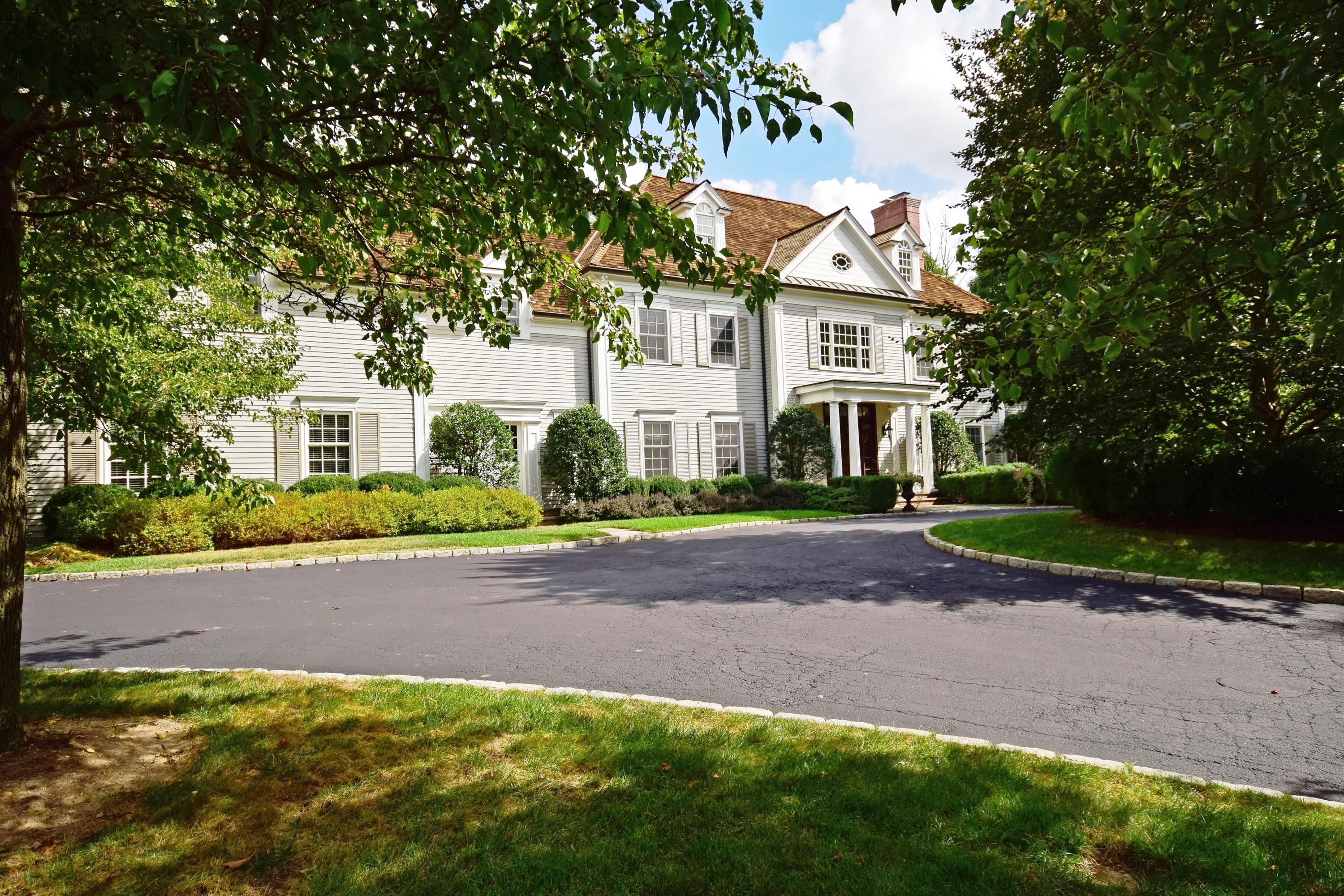 1325 Smith Ridge Road New Canaan, CT 06840 - Photo 2 of 28 a front view of a house with a yard and garage