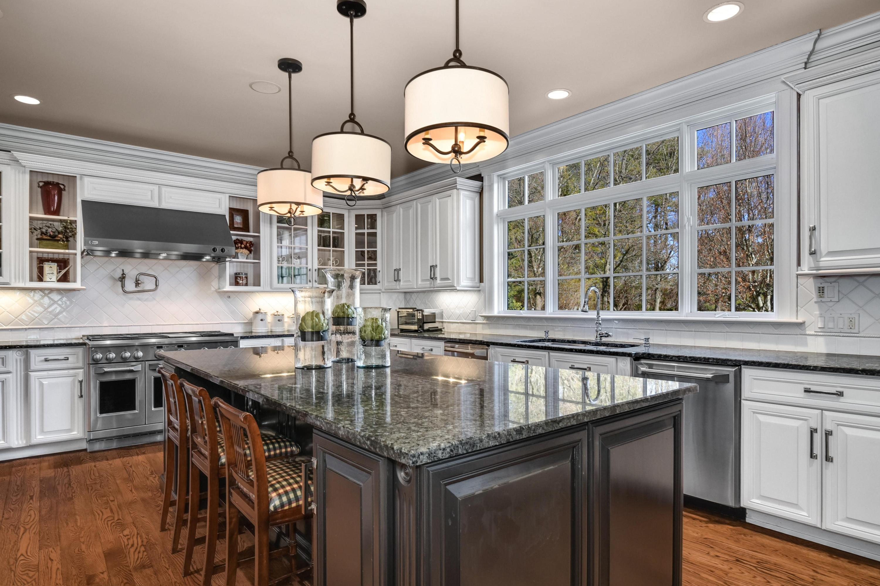1325 Smith Ridge Road New Canaan, CT 06840 - Photo 9 of 28 a large kitchen with granite countertop a stove a sink a dining table and chairs