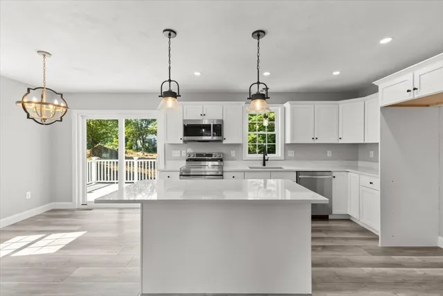 a kitchen with stainless steel appliances granite countertop a stove a sink and a wooden floors