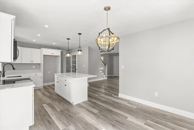 a view of a kitchen with stainless steel appliances granite countertop a sink dishwasher and a stove with wooden floor