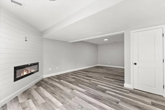 a view of a livingroom with wooden floor and a fireplace