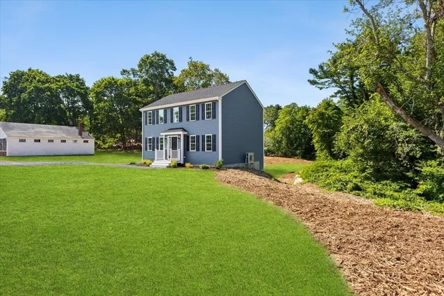 a view of a house with a yard and sitting area