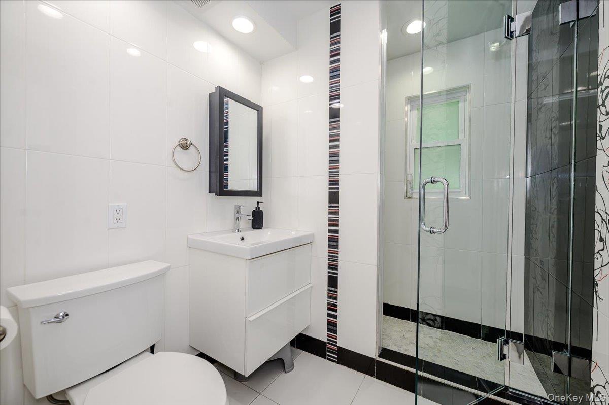 70 Longfellow Road Great Neck, NY 11023 - Photo 22 of 28 a bathroom with a toilet sink and a mirror