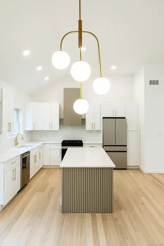 a kitchen with a sink cabinets and wooden floor