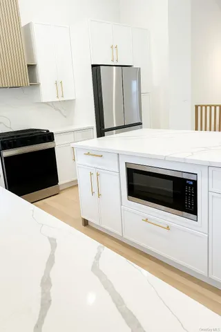 a kitchen with stainless steel appliances a stove a microwave a sink and cabinets