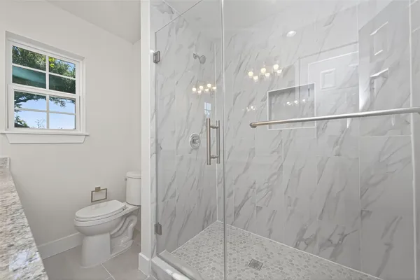 a bathroom with a shower a toilet and a sink