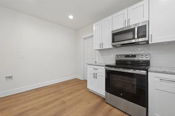 a kitchen with stainless steel appliances granite countertop a stove microwave and sink
