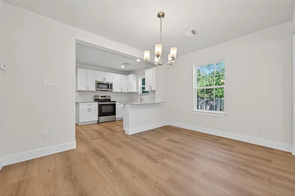 a view of a kitchen with a sink a cabinet and wooden floor