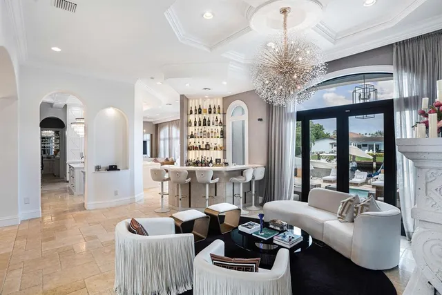 a living room with furniture a flat screen tv and a chandelier