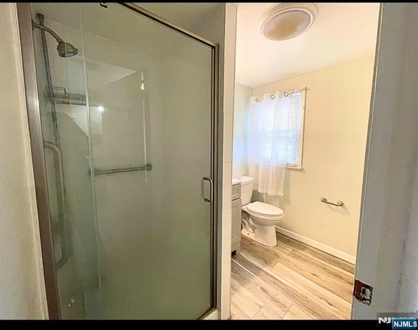 a bathroom with a granite countertop shower a sink and a toilet