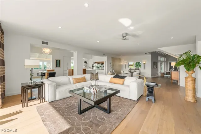 a living room with furniture and a dining table with wooden floor