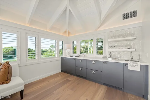 a large kitchen with kitchen island a large window a sink and cabinets