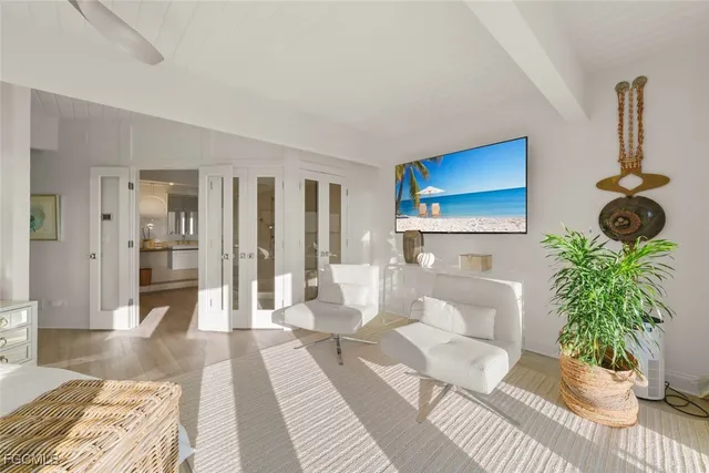 a living room with furniture potted plant and a wooden floor