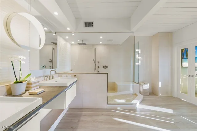 a spacious bathroom with a tub sink and mirror