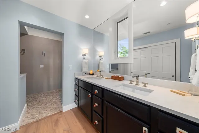 a bathroom with a sink double vanity granite tub shower and a mirror