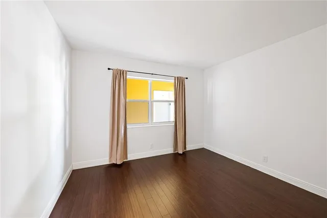 an empty room with wooden floor and a window