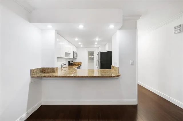 a view of a kitchen with kitchen island and stainless steel appliances
