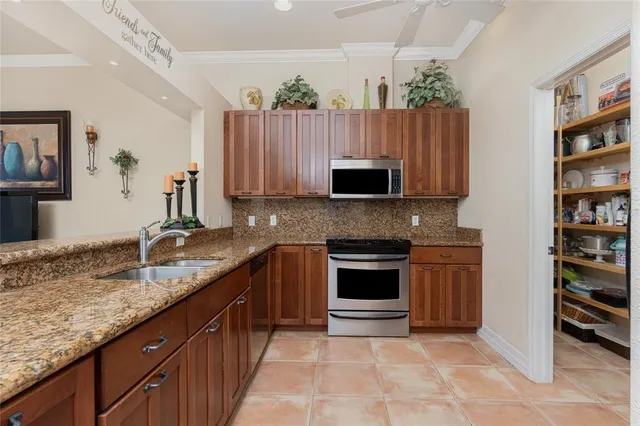 a kitchen with stainless steel appliances granite countertop a stove a sink and a microwave