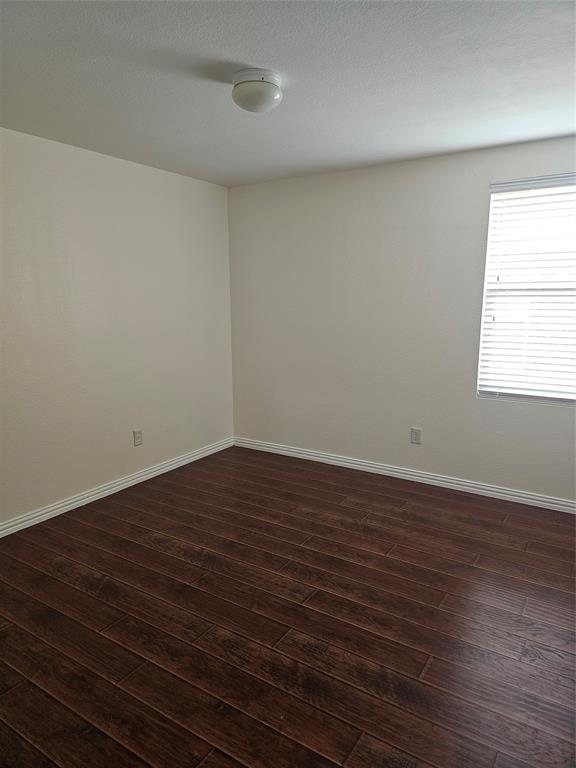 3009 Meadow Bluff Drive Wylie, TX 75098 - Photo 17 of 24 a view of an empty room with wooden floor and a window