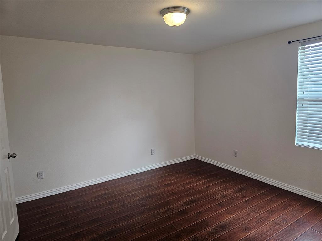 3009 Meadow Bluff Drive Wylie, TX 75098 - Photo 19 of 24 an empty room with wooden floor and windows