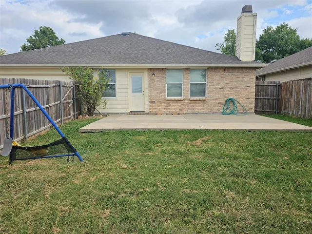 a view of a house with a backyard and a tree