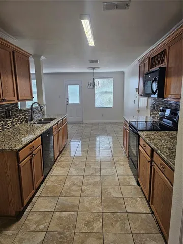 a kitchen with stainless steel appliances granite countertop a stove a sink and a microwave