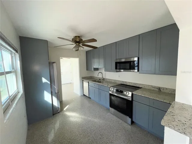 a kitchen with stainless steel appliances granite countertop a stove cabinets and a refrigerator