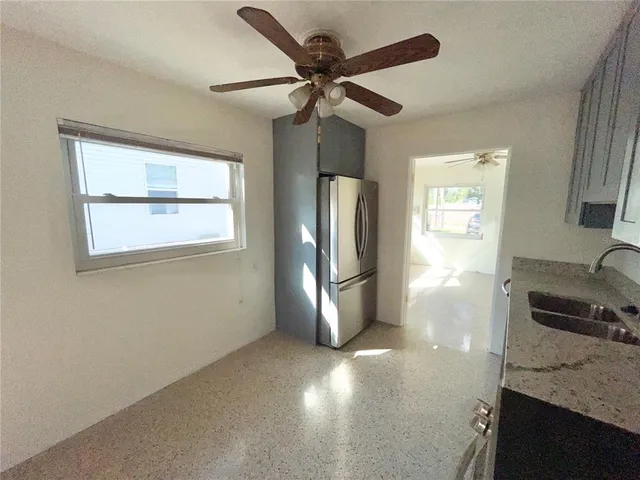 a kitchen with stainless steel appliances granite countertop a refrigerator a stove and a sink