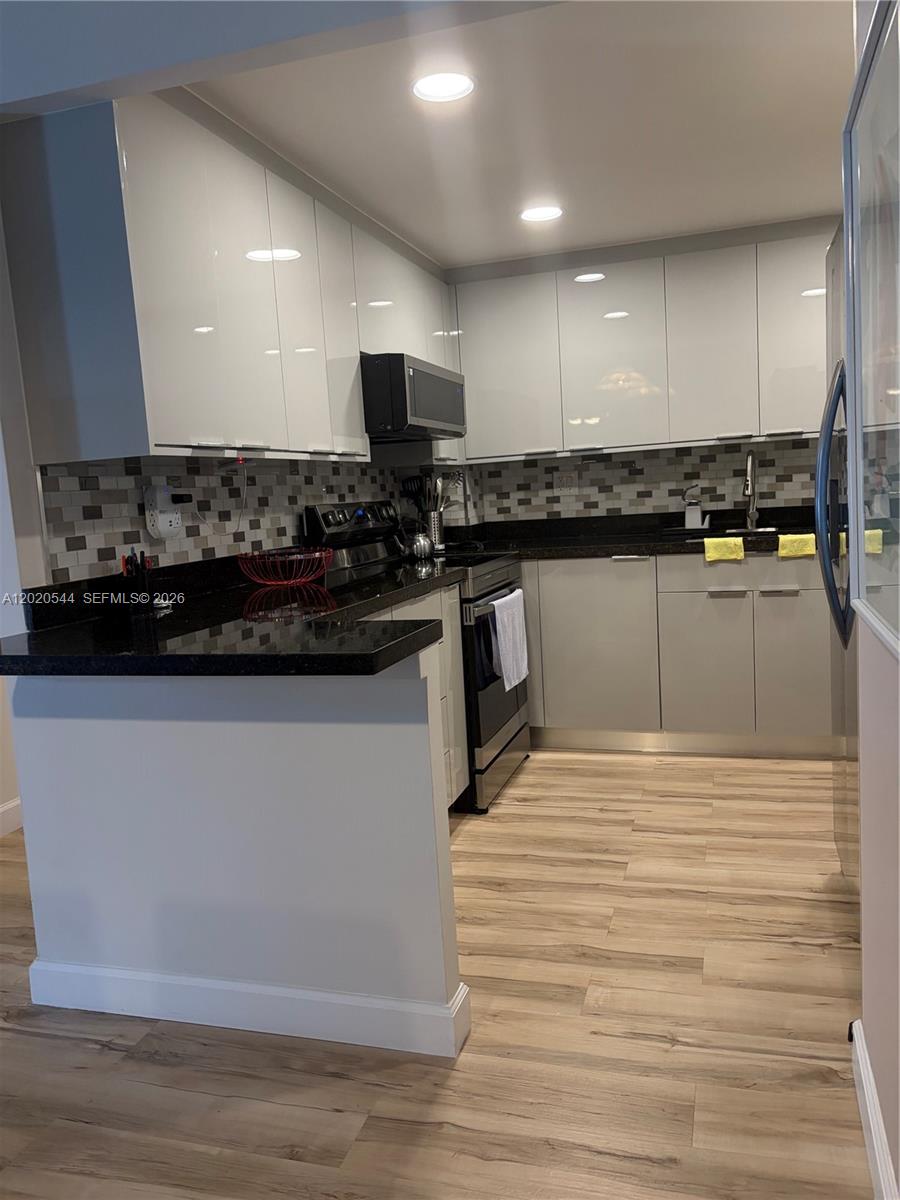 1913 South Ocean Drive, Unit 427 Hallandale Beach, FL 33009 - Photo 9 of 16 a kitchen with stainless steel appliances granite countertop a sink and a stove