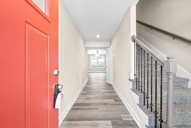 a view of a hallway with wooden floor and staircase