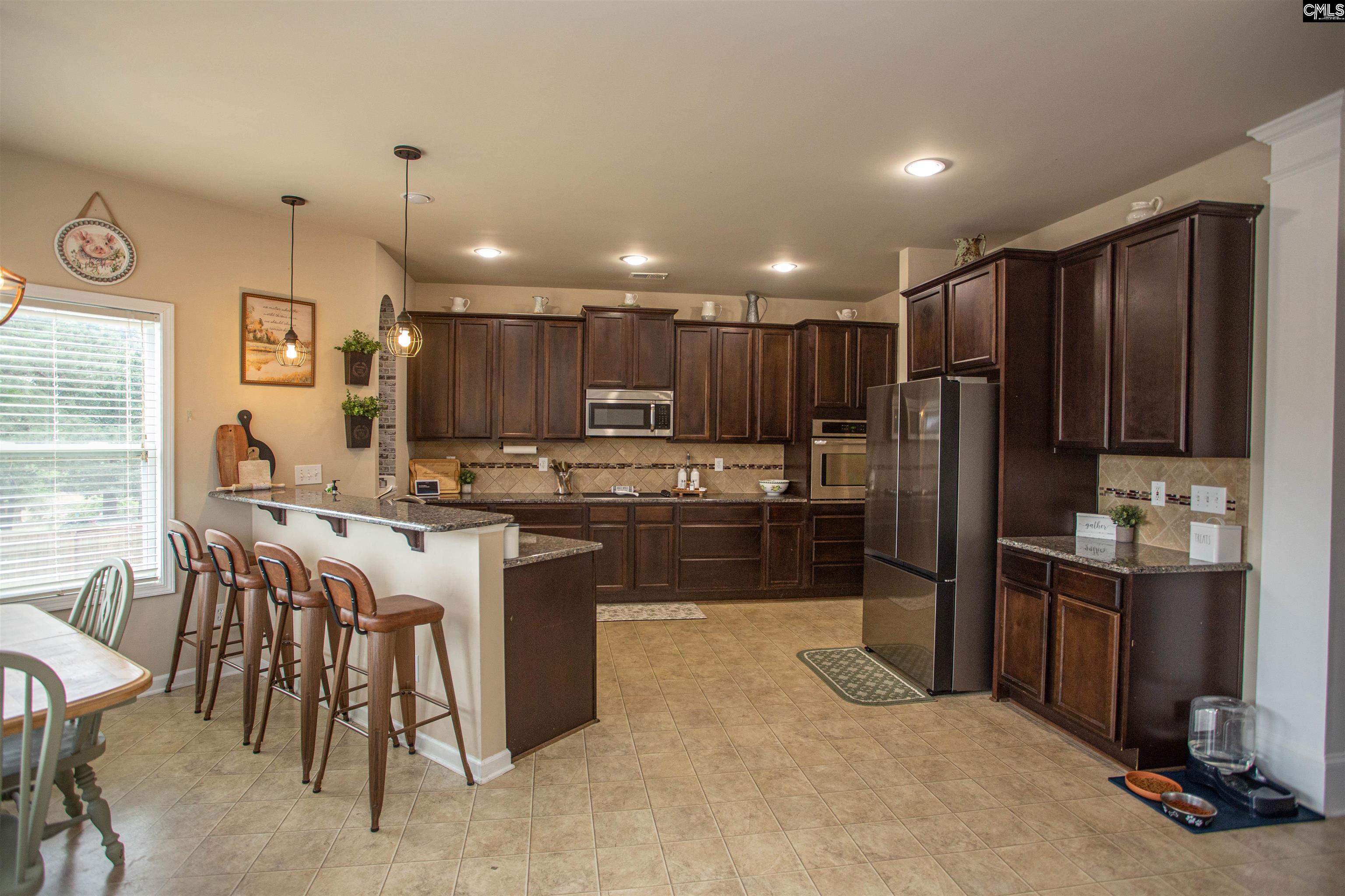 7 Templand Court Elgin, SC 29045 - Photo 12 of 47 a kitchen with kitchen island granite countertop wooden cabinets a counter top space a sink stainless steel appliances and cabinets