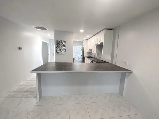 a kitchen with kitchen island a sink stainless steel appliances and counter space