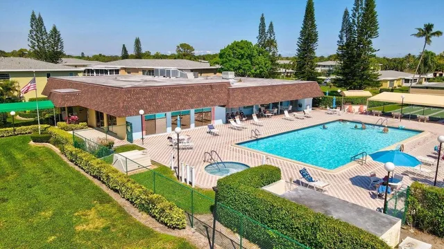 a view of a swimming pool with a patio and a yard