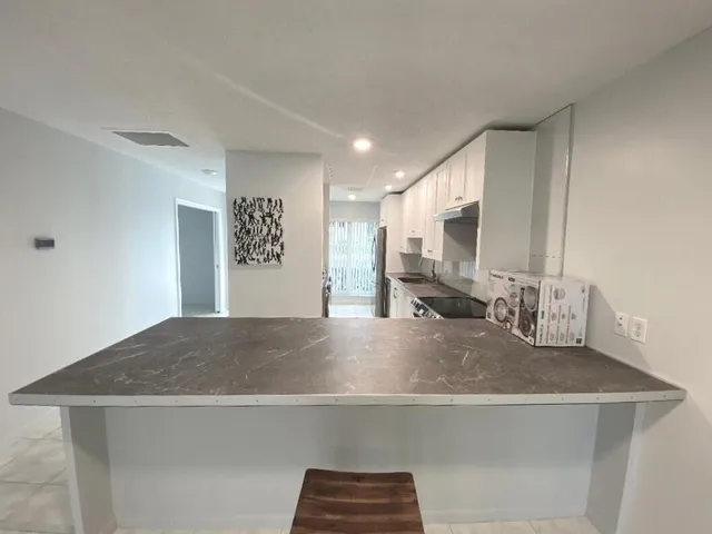 a view of kitchen with kitchen island a sink and a stove