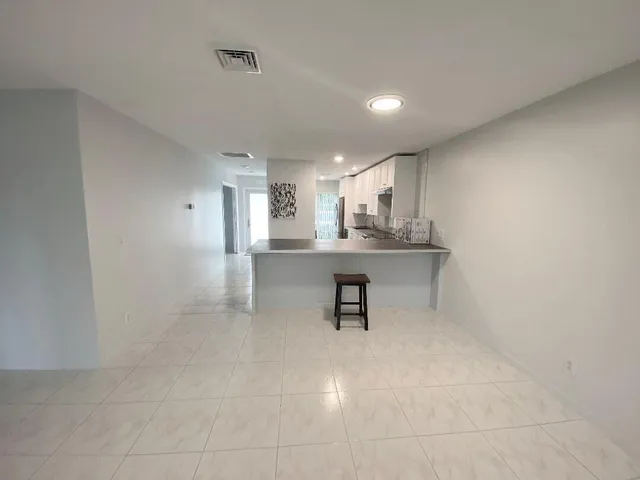 a kitchen with kitchen island a sink and a refrigerator