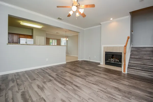 a view of a livingroom with a fireplace a chandelier and wooden floor