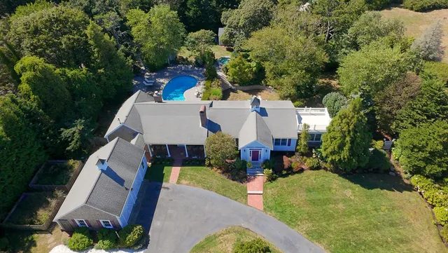 a front view of a house with a yard and potted plants
