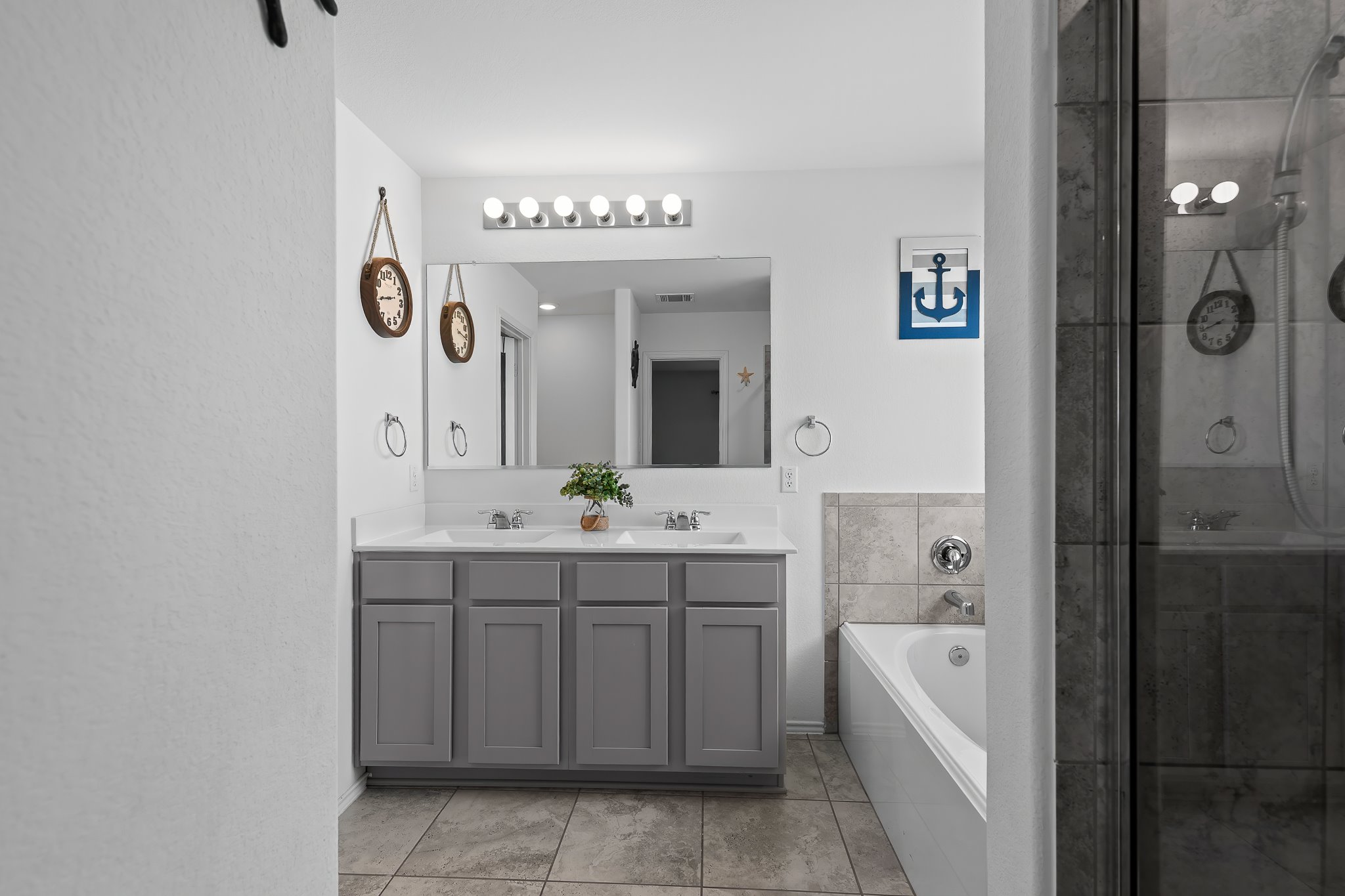 576 Greatest Gift Way Jarrell, TX 76537 - Photo 26 of 37 Dual vanities and a deep soaking tub complete this well-appointed primary bathroom.