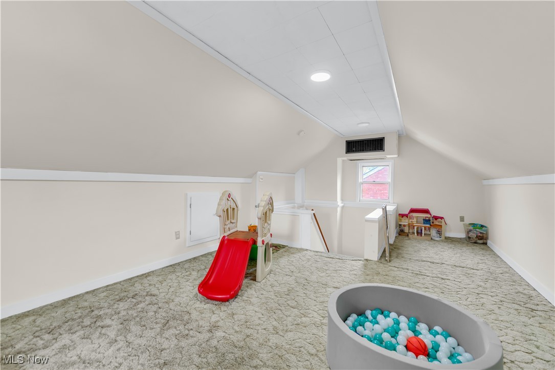 3729 Grosvenor Road Cleveland, OH 44118 - Photo 35 of 39 Recreation room featuring visible vents, baseboards, carpet, and vaulted ceiling