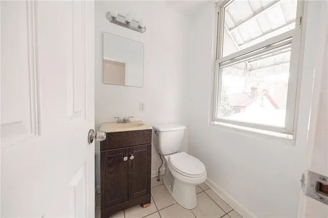 a bathroom with a toilet a sink a window and mirror