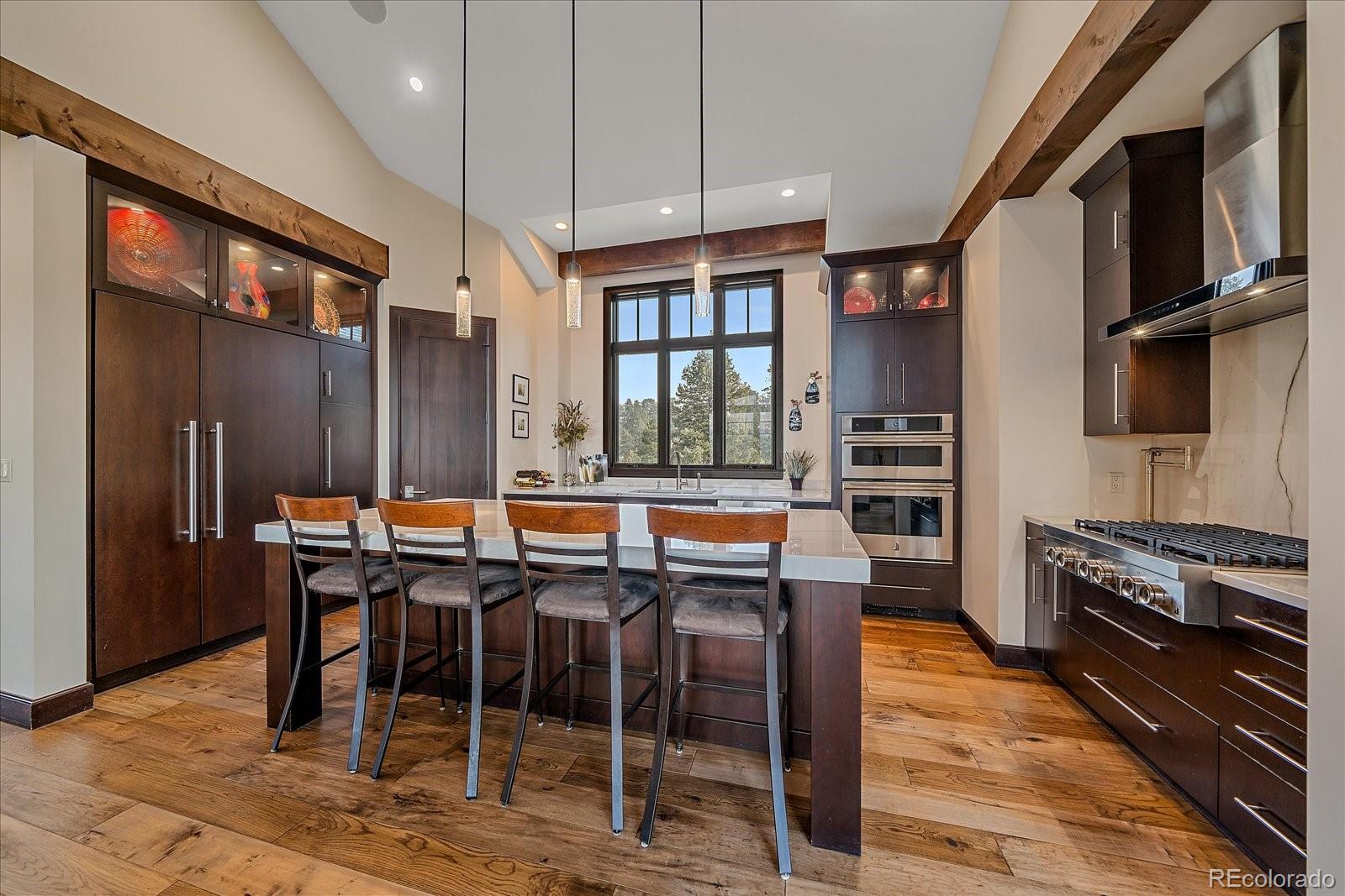 4331 Hilltop Road Evergreen, CO 80439 - Photo 12 of 45 a kitchen with stainless steel appliances granite countertop table chairs and a refrigerator