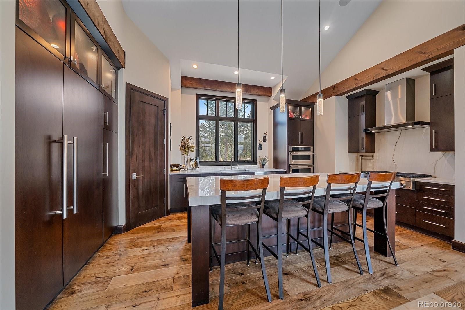 4331 Hilltop Road Evergreen, CO 80439 - Photo 13 of 45 a dining hall with stainless steel appliances granite countertop a table chairs and chandelier
