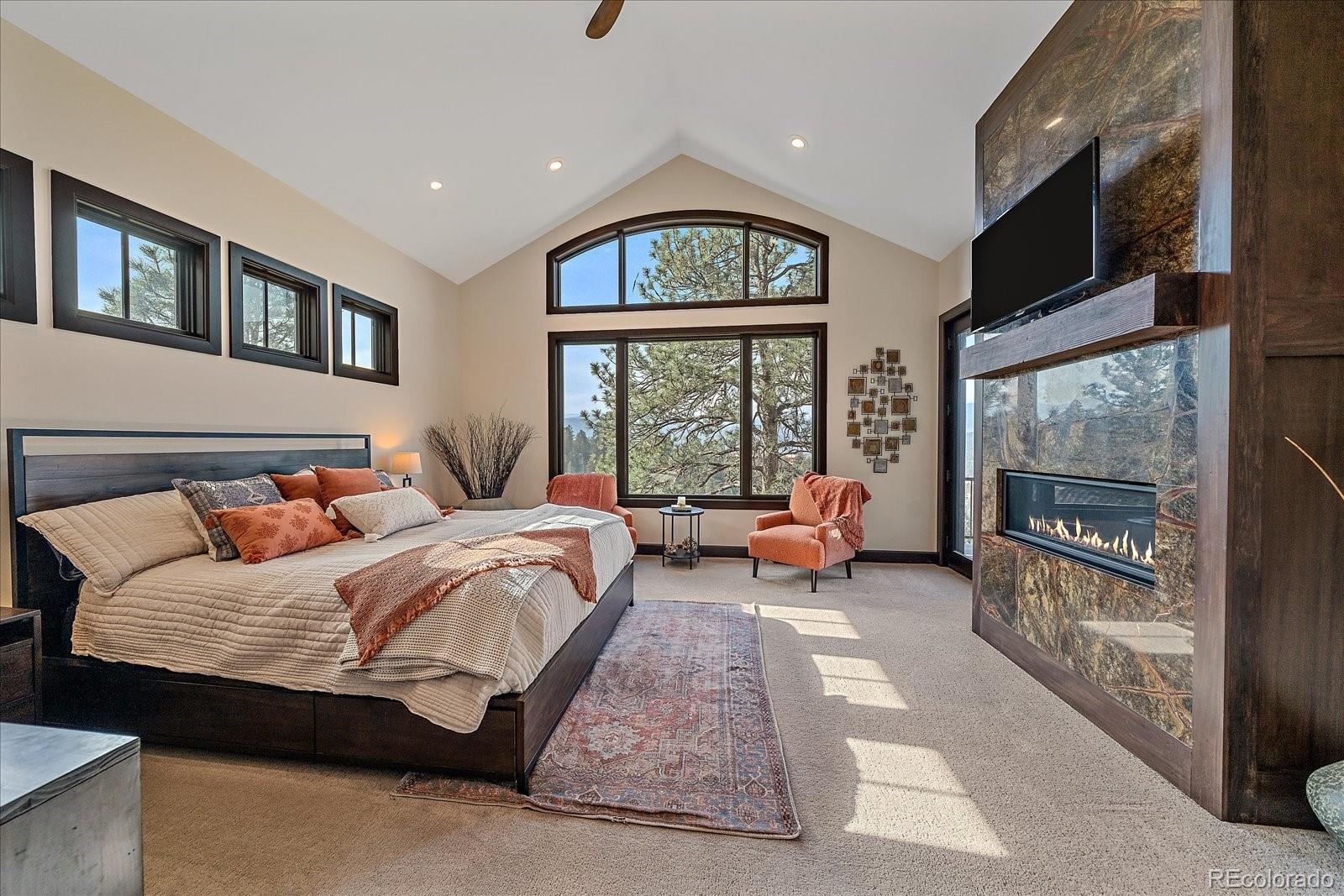 4331 Hilltop Road Evergreen, CO 80439 - Photo 15 of 45 a bedroom with a bed and a large window